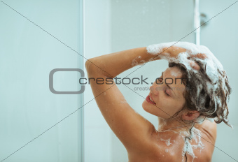 Woman applying shampoo in shower