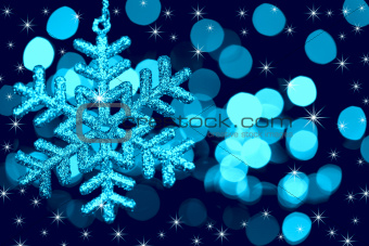 Christmas decoration snowflake  on defocused lights and stars ba