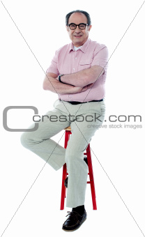 Seated senior man with folded arms
