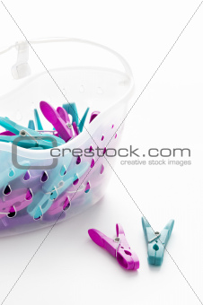 coloured plastic clothes pegs and basket