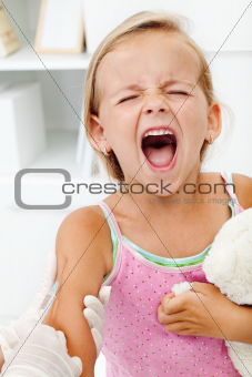 Distressed little girl getting an injection or vaccine