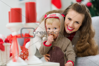 smiling young mother and baby eating Christmas cookie