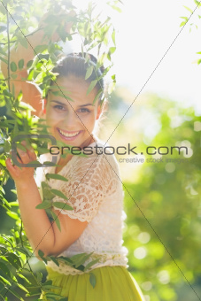 Smiling young woman playing in foliage