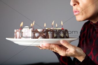 blowing out small candles on cake