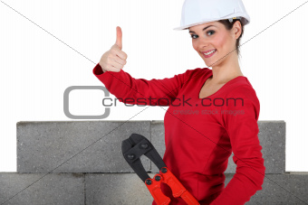 Female bricklayer giving thumbs-up