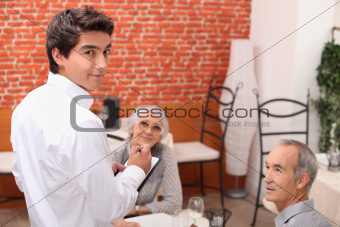 mature couple at restaurant with waiter
