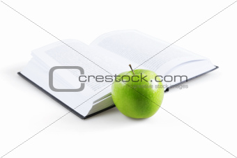art book and ripe green apple