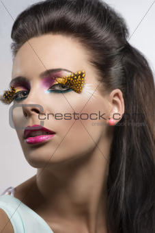 girl with feathered makeup turned at right