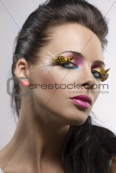 girl with feathered makeup turned at left