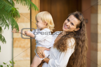Happy mother showing baby plants outdoors