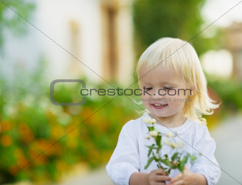Portrait of baby with flowers outdoors