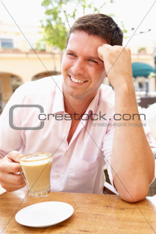Young Man Enjoying Cup Of Coffee In Caf