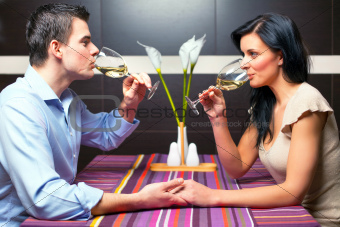 Young couple drinking wine and flirting 