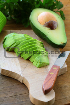 ripe cleaned peeled avocado sliced on the board