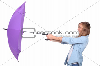 Young woman struggling with a purple umbrella on a windy day
