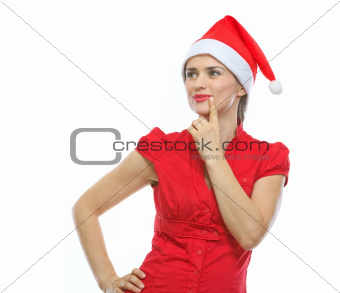 Portrait of thinking young woman in Santa hat looking on copy space