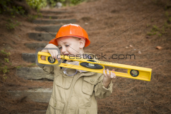 Happy Adorable Child Boy with Level, Hard Hat and Goggles Playing Handyman Outside.