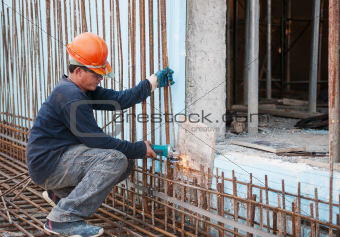Construction worker cutting steel rods