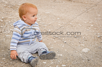 A child sitting on a background a bank