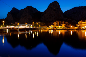 Mountain Silhouettes and Illuminated Town of Omis Reflecting in 