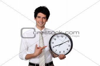 Happy businessman showing a clock