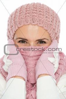 Woman in knit winter clothing closing face with scarf