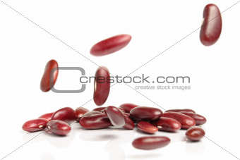 Falling red beans on white background