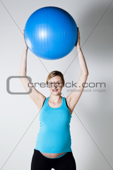 Pregnant woman stretching with fitness ball