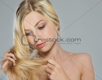 Portrait of blond girl checking hair ends