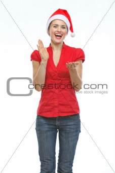 Happy young woman in Christmas hat clapping hands