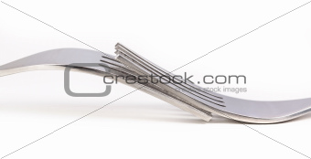 Two forks on white surface