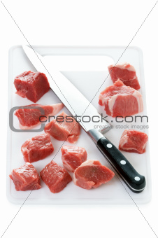 raw cubes lamb on a chopping board