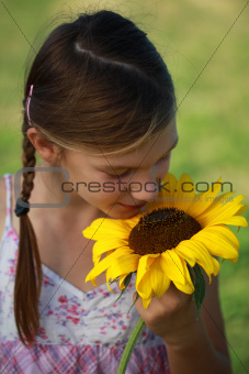 Young girl smelling a sunflower
