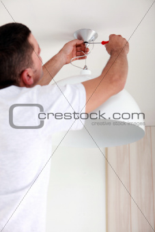 Man fixing ceiling light