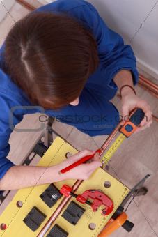 a female technician working on a copper tube