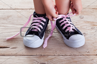 Child hands tie up shoe laces