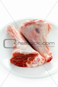 two raw uncooked lamb shanks