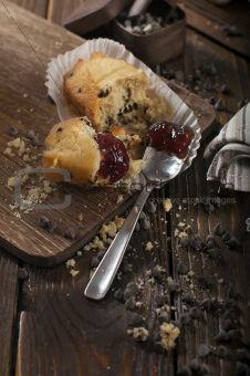 Broken cupcake with jam and chocolate drops.