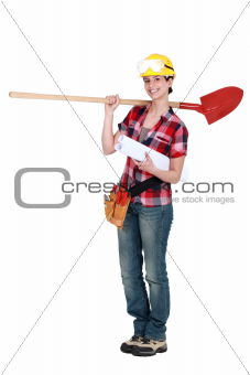 Female construction worker holding plans and spade