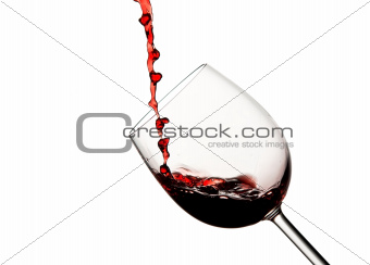 Crystal wine glass with pouring red wine