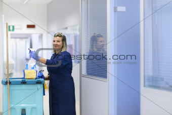 Portrait of happy professional female cleaner smiling in office