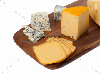 Different types of cheese on wooden kitchen board