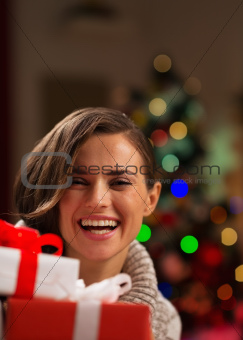 Happy young woman looking out from Christmas gift boxes