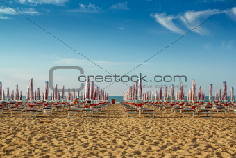 withdrawn umbrellas and sunlongers on the sandy beach