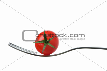cherry tomato on a fork against white