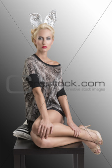sexy girl with silver bunny ears and knees on table