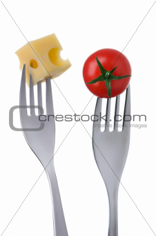 tomato and cheese on forks against white