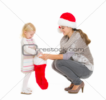 Baby girl taking out present from Christmas sock