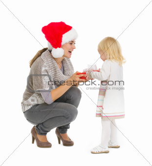 Happy mother making Christmas present to baby girl