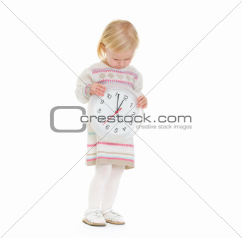 Christmas portrait of baby girl looking on clock